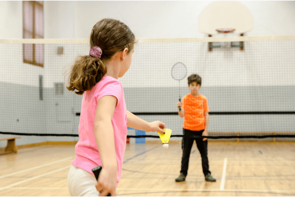 Jóvenes escolares jugando al bádminton